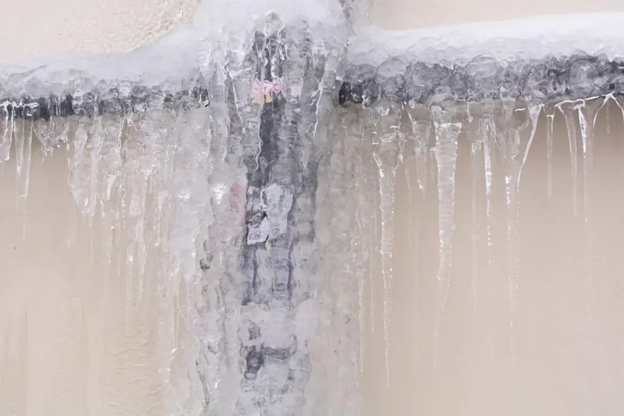 A frozen, burst pipe covered in ice in an Alpharetta, GA home